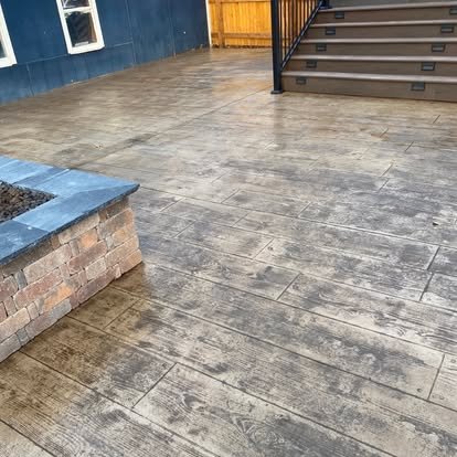 Stamped concrete patio with fire pit surround — wood plank texture pattern in weathered grey